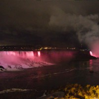 Niagarafälle bei Nacht. Zwischen den beiden Fällen verläuft die Grenze zwischen den USA und Kanada